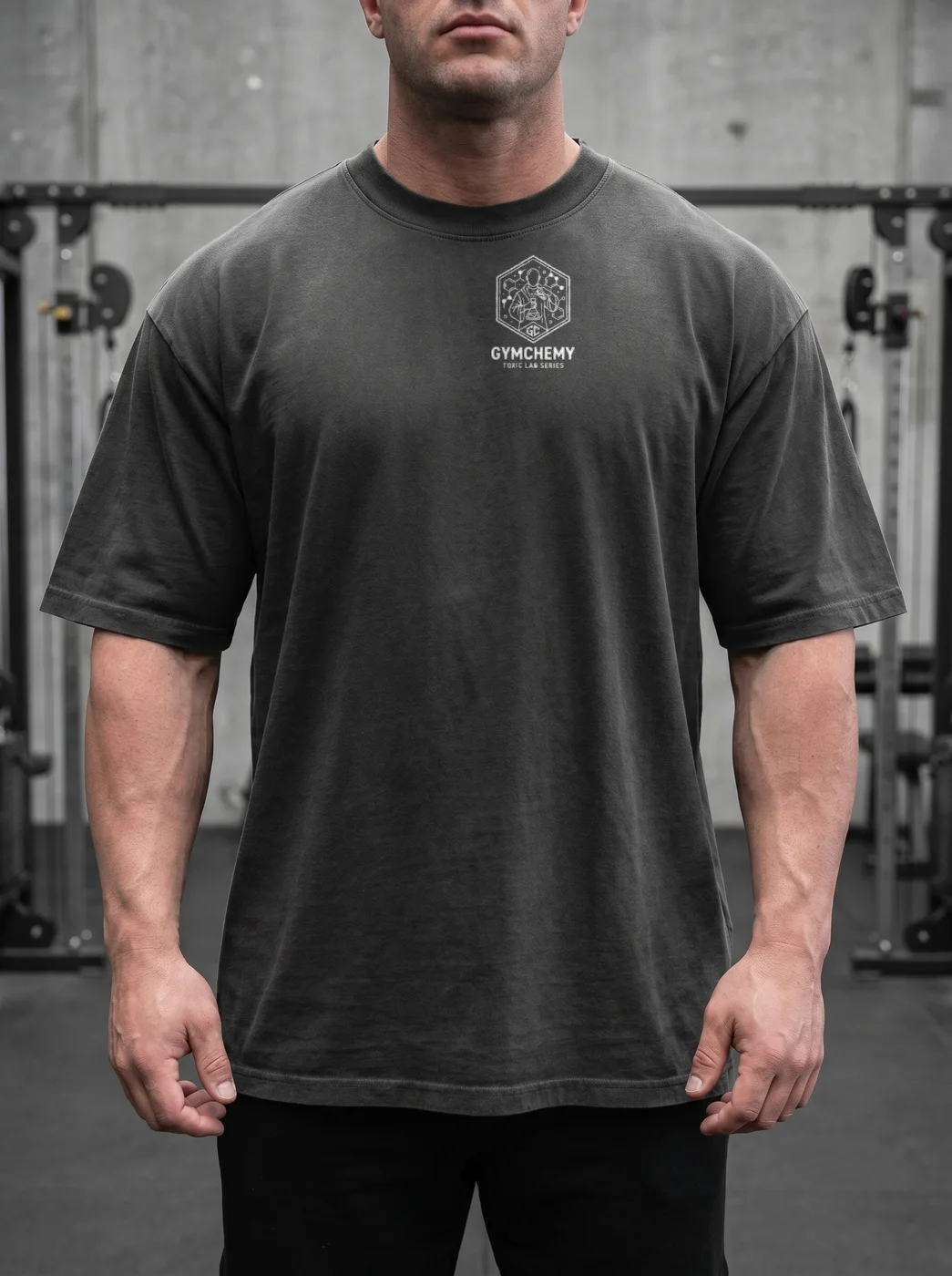 Vista frontale di una tee nera Gymchemy con piccola stampa hypertrophy-division sul petto, fit oversize.